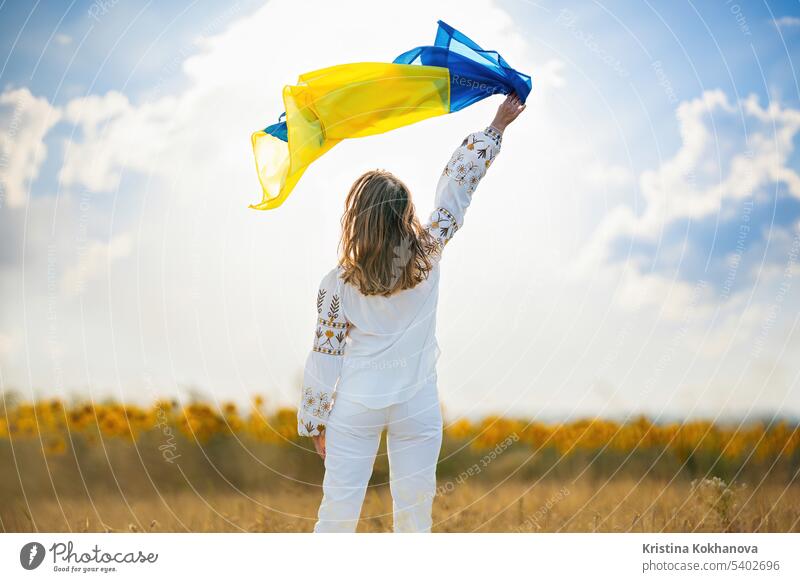 Glückliche ukrainische Frau mit Nationalflagge auf Sommerhimmel Hintergrund. Freiheit Mädchen Selbstständigkeit national im Freien Patriotin patriotisch