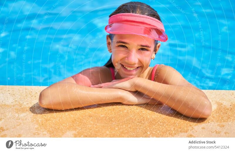 Junges Mädchen mit Sonnenschutzkappe entspannt sich mit den Händen am Beckenrand Pool Porträt Lächeln Glück genießen ruhen Urlaub Wasser Kind Feiertag niedlich