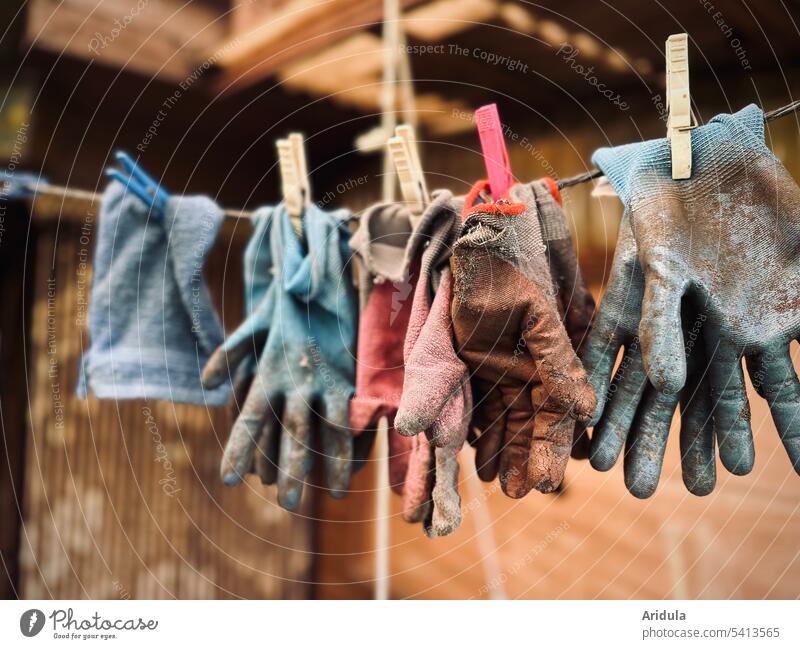 Gartenhandschuhe und ein Waschlappen hängen auf einer Wäscheleine Handschuhe Gartenarbeit Arbeit Gärtner Wäscheklammern alt kaputt verschlissen