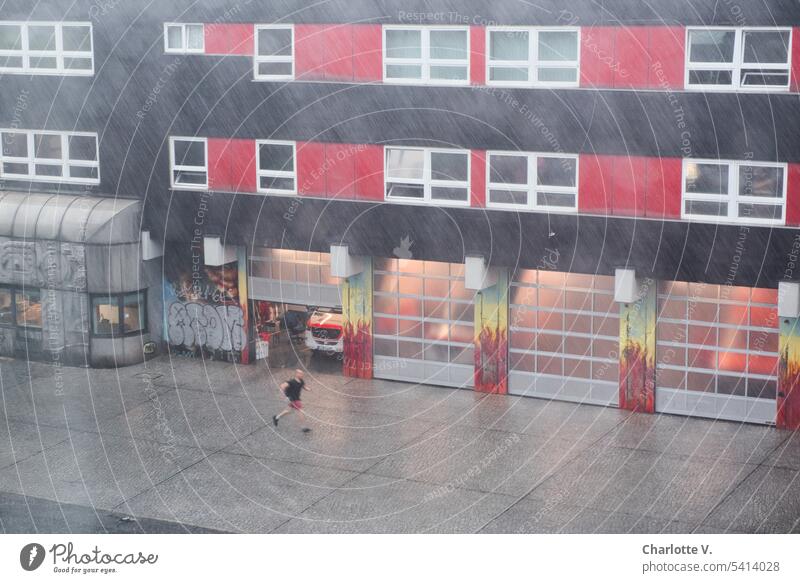 Sommergewitter vor der Feuerwehr Regen schlechtes Wetter Außenaufnahme nass Farbfoto eine Person Umwelt Regenguss Regenwetter rennen flüchten feucht