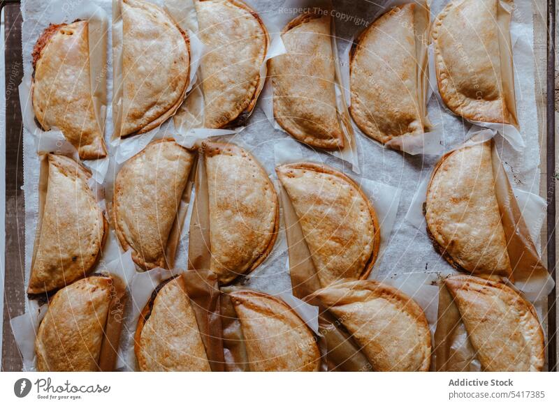 Backblech mit komponierten, frisch gebackenen Pasteten Patty Bäckerei golden Tablett Lebensmittel traditionell Küche selbstgemacht geschmackvoll lecker Snack