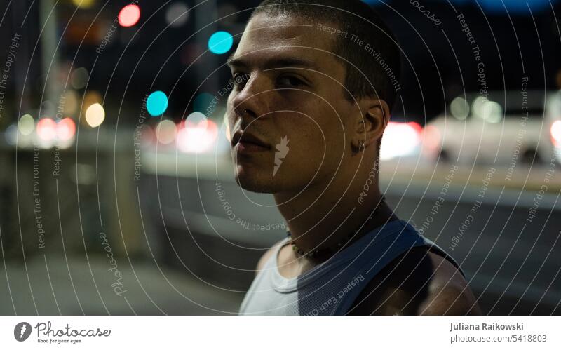 Portrait eines jungen Mannes nachts in der Stadt nachtspaziergang Straßenbeleuchtung trendy Blick streetstyle Street Photography urban nächtlich Gesicht