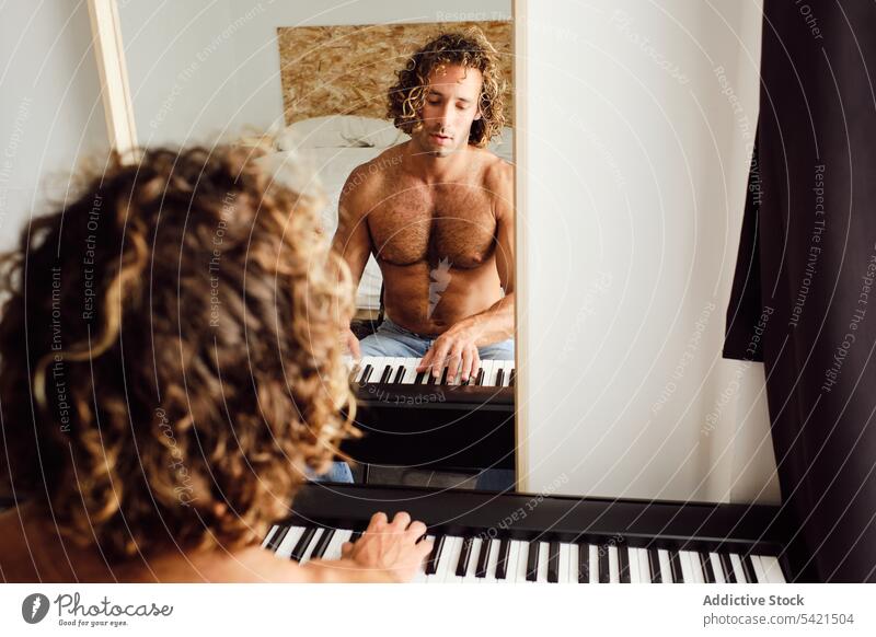 Mann ohne Hemd spielt zu Hause Klavier spielen Probe Musiker Melodie Instrument üben Pianist männlich Fähigkeit Klang Keyboard heimwärts Spieler unterhalten