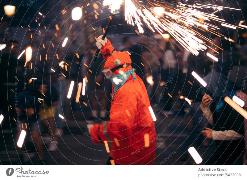 Unbekannte Person mit brennendem bengalischen Licht Weihnachten Wunderkerze Tracht Straße Veranstaltung feiern Nacht festlich Feiertag Winter Tradition Funken