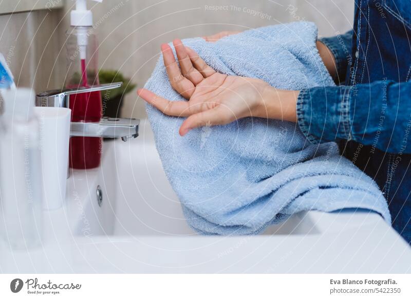 Unbekannte Frau trocknet sich nach dem Waschen mit Seife die Hände mit einem Handtuch. Coronavirus covid-19 Konzept Wäsche waschen Corona-Virus zu Hause bleiben