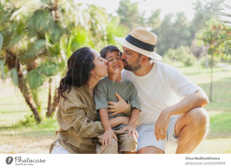 glückliche Familie lächelnd mit einem Sohn im Park im Freien im Sommer Mama Papa Vater Mutter Elternschaft Vaterschaft Mutterschaft Liebe Zusammensein Kind