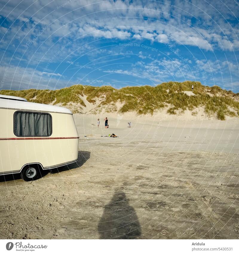 Strandszenerie | Alter Wohnwagen, vier Menschen und Schatten der Fotografin vor Nordseedüne mit Dünengras im Sonnenschein Ferien & Urlaub & Reisen Sand