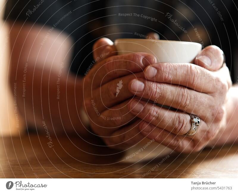 Männerhände wärmen sich an einer Kaffeetasse Tasse Heißgetränk aufwärmen Kaffeepause Tasse in den Händen gemütlich Kaffeetrinken Getränk genießen Genuß