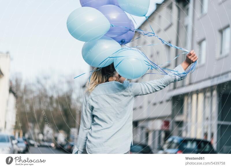 Rückenansicht einer Frau mit blauen Luftballons blauer blaues Ballon Ballons Luftballone weiblich Frauen Farbe Farbtöne Farbtoene Farbton Farben Dekoration