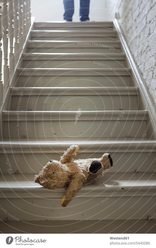 Teddybär auf Stufen, während der Mann im Hintergrund Geländer Gelaender Einsamkeit einsames einsamer einsamen Nostalgie nostalgisch Textfreiraum Treppenstufen