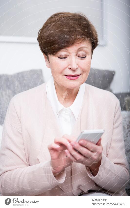 Porträt einer älteren Frau mit Smartphone sitzen sitzend sitzt Seniorin Seniorinnen alt weiblich Frauen Senioren Erwachsener erwachsen Mensch Menschen Leute