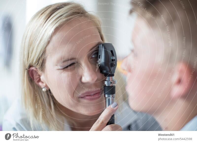 Weibliche Pädiaterin untersucht Jungen mit einem Otoskop Ohrenspiegel Otoskope Buben Knabe Knaben männlich Kinderarzt Kinderärzte Kinderaerzte Medizin