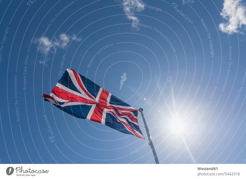 Union Jack bei blauem Himmel mit Gegenlicht Wolke Wolken Blauer Himmel Sonnenschein sonnig Nationalität Nationalitaet Textfreiraum Britische Flagge Lichtstrahl