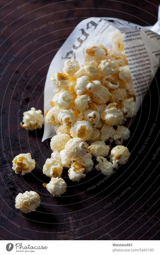 Papiertüte mit Popcorn Papiere Ausschnitt Teil Teilansicht Teilabschnitt Anschnitt Teil von Detail verstreut Papiertüten bedruckt servierfertig angerichtet Mais