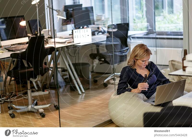 Geschäftsfrau mit Bierflasche und Laptop im Büro Notebook Laptops Notebooks Geschäftsfrauen Businesswomen Businessfrauen Businesswoman trinken Office Büros