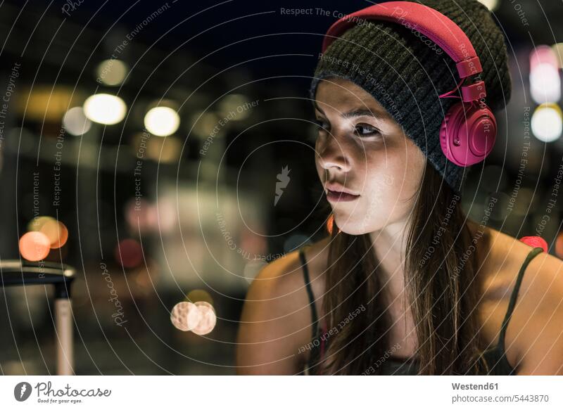 Porträt einer jungen Frau mit Kopfhörern bei Nacht weiblich Frauen Kopfhoerer nachts Erwachsener erwachsen Mensch Menschen Leute People Personen warten Musik