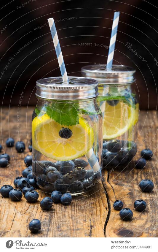 Zwei Gläser Aufgusswasser mit Zitronenscheiben, Heidelbeeren und Minze verstreut Deckel gesund Pfefferminze Mineralwasser Wasser servierfertig angerichtet