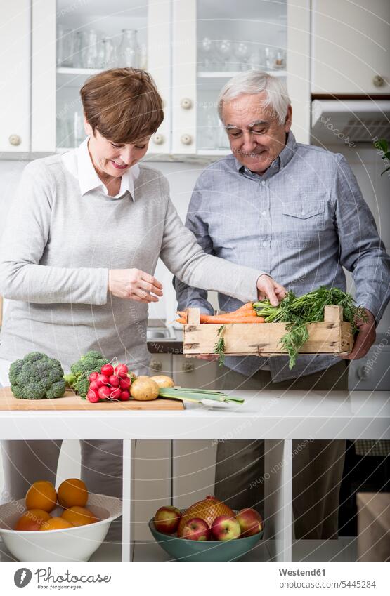 Älteres Ehepaar steht in der Küche und packt frisches Gemüse aus Europäer Kaukasier Europäisch kaukasisch Gemuese stehen stehend Gemeinsam Zusammen Miteinander