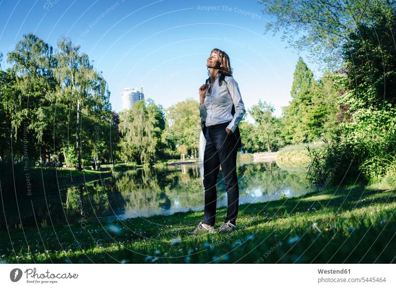 Geschäftsfrau entspannt sich im Park Parkanlagen Parks Spaziergang genießen geniessen Genuss Geschäftsfrauen Businesswomen Businessfrauen Businesswoman stehen