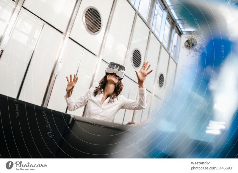 Geschäftsfrau mit VR-Brille im Büro entdecken stehen stehend steht Virtual Reality Brille Virtual-Reality-Brille Virtual Reality-Brille VR Brille Cyberspace