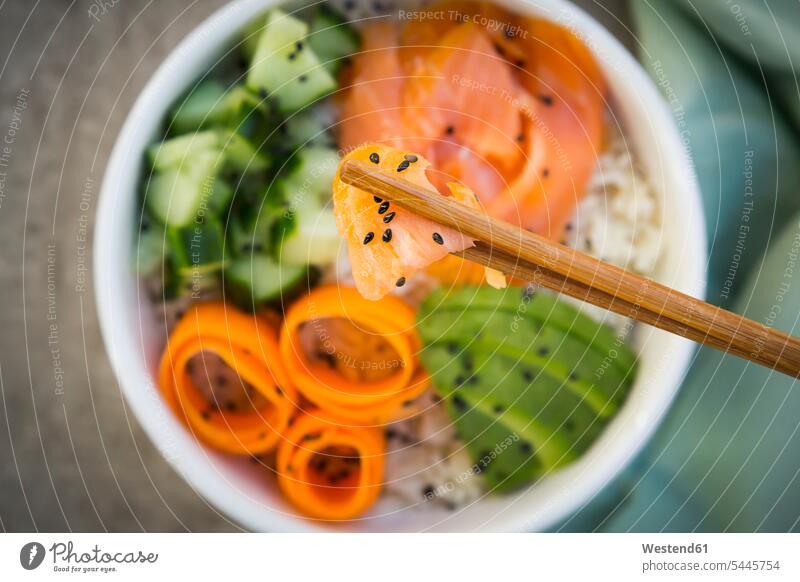 Sushi-Schüssel mit Lachs, Gurke, Avocado, Reis und Karotte, Lachs und Stäbchen im Vordergrund Draufsicht Vogelperspektive von oben Aufsicht Niemand