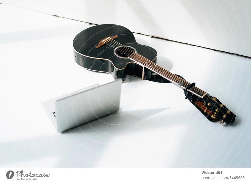 Laptop und akustische Gitarre auf weißem Boden Gitarren Textfreiraum Erhöhte Ansicht Erhöhte Ansichten Abwesenheit menschenleer abwesend Schlichtheit