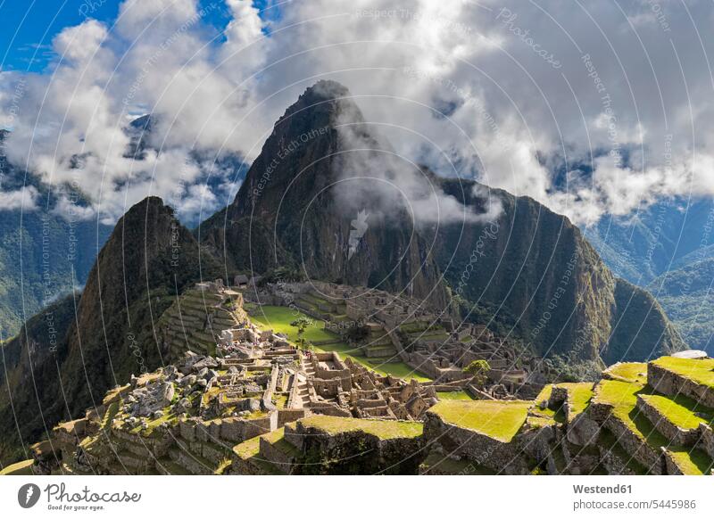 Peru, Anden, Urubamba-Tal, Machu Picchu mit dem Berg Huayna Picchu Wolke Wolken Sonnenlicht Ruine Ruinenstätte Ruinenstaette Berge Architektur Baukunst
