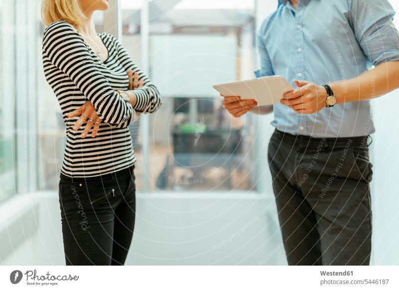 Geschäftsmann und -frau stehen im Korridor und unterhalten sich Besprechung Besprechungen Büro Office Büros Geschäftsleute Geschäftspersonen Gemeinsam Zusammen