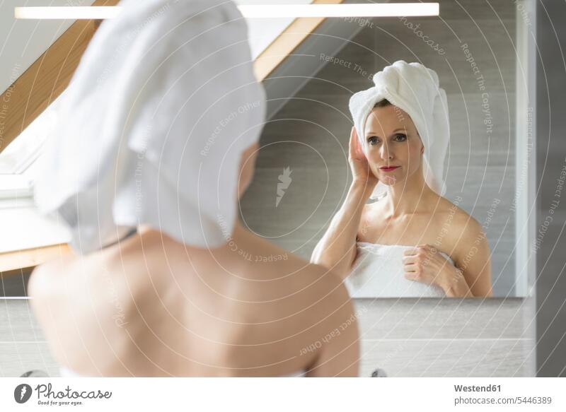 Frau schaut auf ihr Spiegelbild im Badezimmer Portrait Porträts Portraits weiblich Frauen Spiegelbilder Erwachsener erwachsen Mensch Menschen Leute People