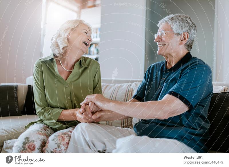 Glückliches älteres Ehepaar zu Hause Sofa Couches Liege Sofas glücklich glücklich sein glücklichsein Paar Pärchen Paare Partnerschaft Senior ältere Männer