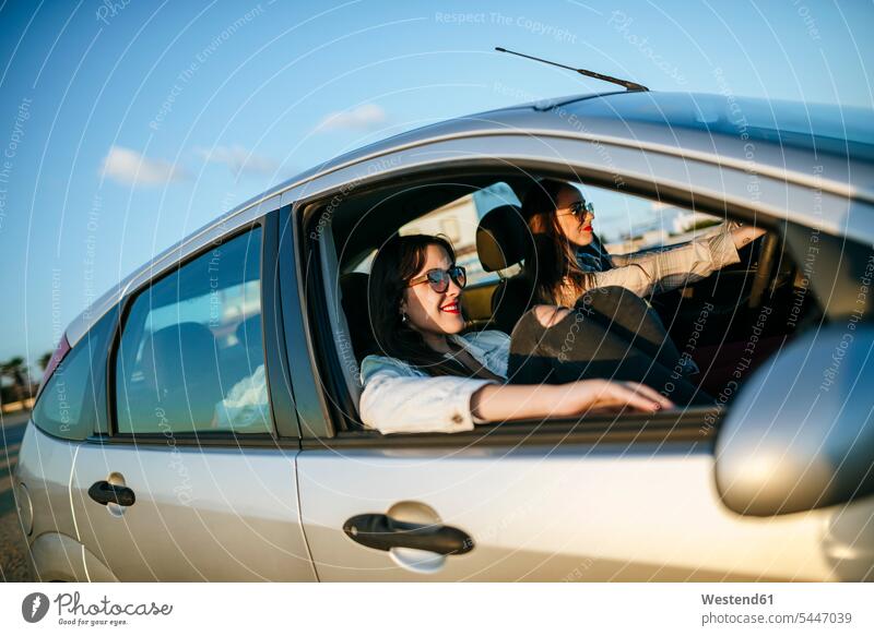 Zwei junge Frauen reisen in einem Auto Freundinnen Wagen PKWs Automobil Autos Freunde Freundschaft Kameradschaft Kraftfahrzeug Verkehrsmittel KFZ