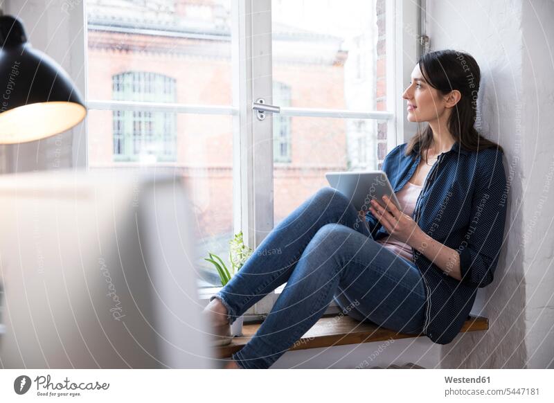 Frau mit Tablett, die im Büro aus dem Fenster schaut Office Büros Arbeitsplatz Arbeitsstätte Arbeitstelle Tablet Computer Tablet-PC Tablet PC iPad