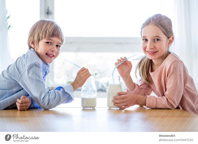 Bruder und Schwester trinken Milch Brüder Schwestern lächeln Geschwister Familie Familien Mensch Menschen Leute People Personen Getränk Getraenk Getränke