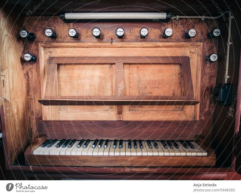 Orgel in einer kleinen Dorfkirche Tasten Klaviatur Tasteninstrumente Musik Detailaufnahme Orgel Holz Register Notenständer alt gediegen Innenaufnahme Klang