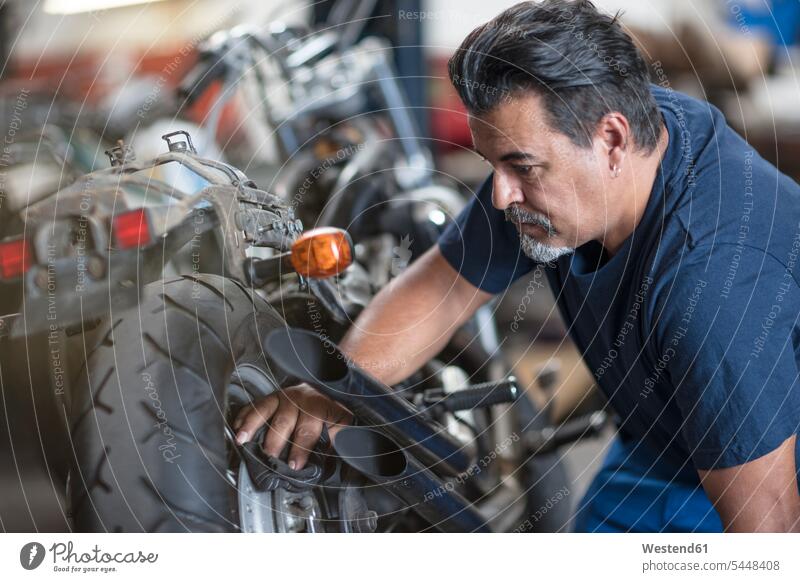 Mechaniker reinigt Motorrad in Werkstatt Motorräder putzen reinigen reparieren Reparatur Monteur arbeiten Arbeit Kraftfahrzeug Verkehrsmittel KFZ Industrie