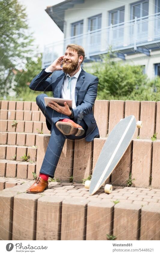 Geschäftsmann mit Skateboard, Tablet und Kopfhörer am Telefon Businessmann Businessmänner Geschäftsmänner telefonieren anrufen Anruf telephonieren