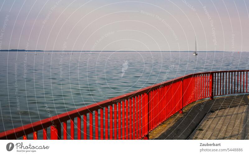 Rotes Geländer, Meer, Horizont und ein Segelboot in der Ferne rot segeln Weite Fernweh Reise Wasser Küste Segeln Ferien & Urlaub & Reisen Sommer Freiheit