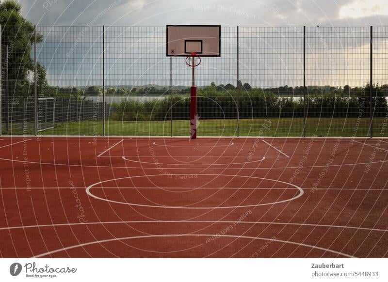 Sportplatz, Basketballfeld mit Basketballkorb und Zaun, weiße Linien auf rotem Grund Korb spielen Spaß Ballspiel Ballsport Freizeit & Hobby Basketballplatz