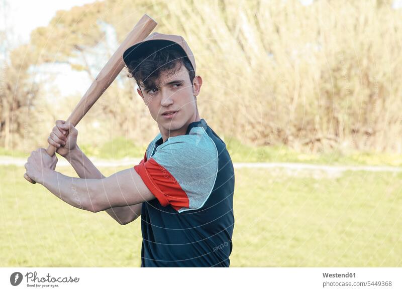 Porträt eines jungen Mannes mit Baseballschläger im Park Baseballspieler Baseballer Männer männlich Schläger Sport Erwachsener erwachsen Mensch Menschen Leute