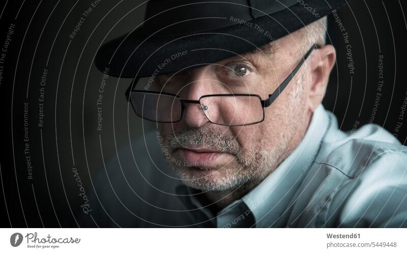 Porträt eines seriös aussehenden älteren Mannes mit Brille und Hut Männer männlich Portrait Porträts Portraits Brillen Hüte ernst Ernst Ernsthaftigkeit