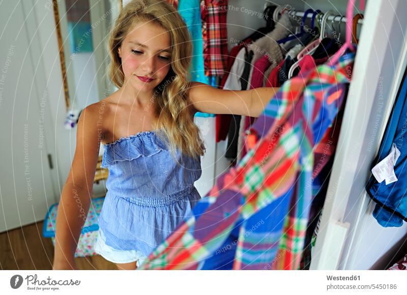 Mädchen wählt Kleidung aus dem Kleiderschrank weiblich schauen sehend aussuchen auswählen Kind Kinder Kids Mensch Menschen Leute People Personen Europäer