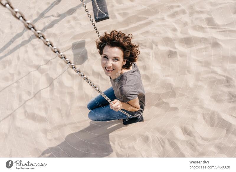 Glückliche Frau auf einer Schaukel weiblich Frauen Strand Beach Straende Strände Beaches lächeln Schaukeln Erwachsener erwachsen Mensch Menschen Leute People