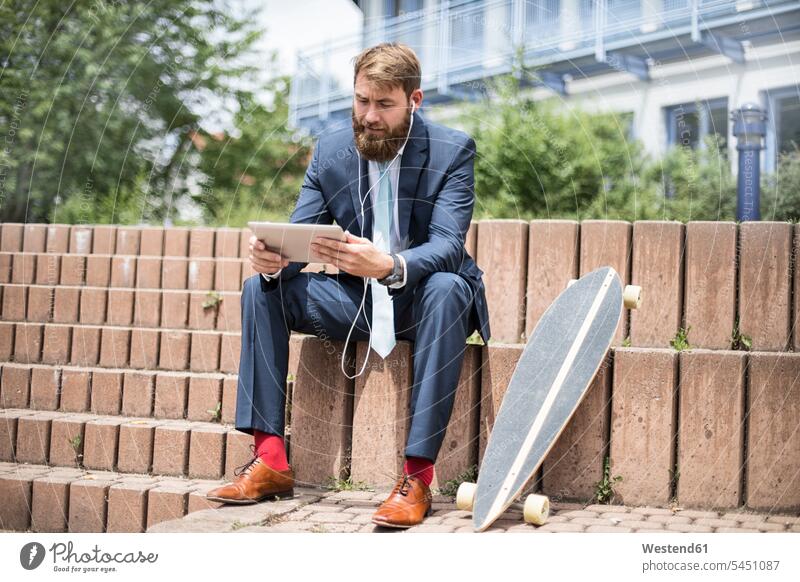 Geschäftsmann mit Skateboard mit Tablet und Kopfhörer Tablet Computer Tablet-PC Tablet PC iPad Tablet-Computer Businessmann Businessmänner Geschäftsmänner