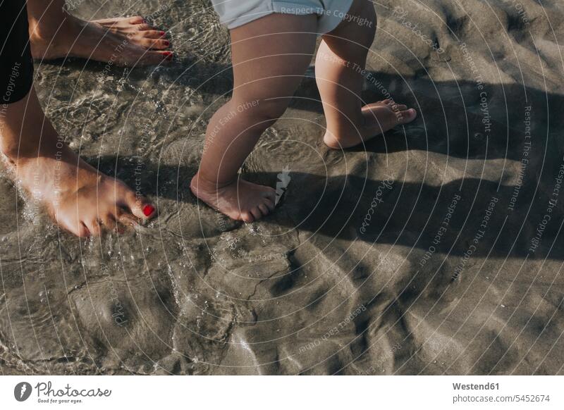 Mutter mit kleiner Tochter watet am Strand im Wasser Mami Mutti Mütter Mama Töchter Beach Straende Strände Beaches Eltern Familie Familien Mensch Menschen Leute