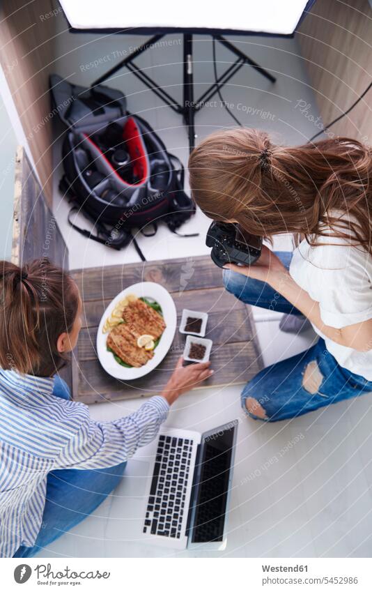 Frau stylt zubereitetes Gericht während der Fotosession Fotokamera Kamera Kameras Leute Menschen People Person Personen erwachsen Erwachsene Frauen weiblich