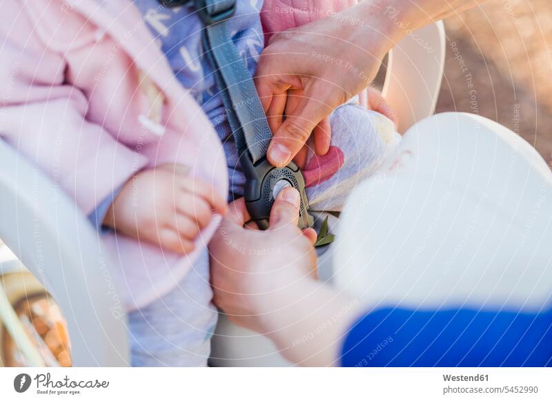 Mutter befestigt Baby im Fahrradkindersitz anschnallen Kindersitz Mädchen weibliche Babys weibliches Baby weibliche Babies radfahren fahrradfahren radeln