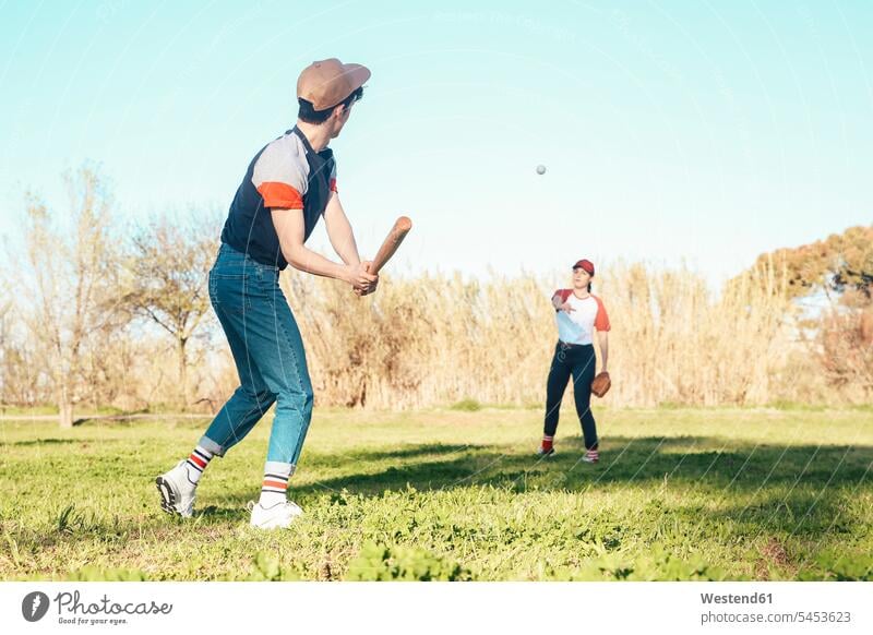 Junges Paar spielt Baseball im Park Pärchen Paare Partnerschaft Baseballspiel Baseballspieler Baseballer spielen Mensch Menschen Leute People Personen Sport