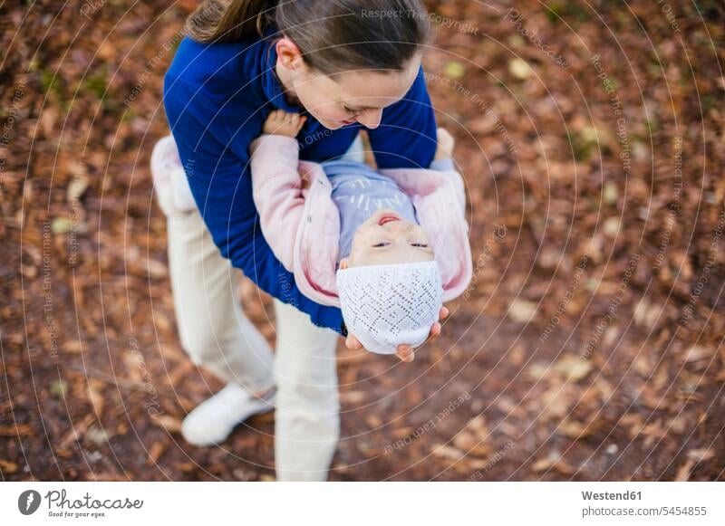 Mutter umarmt Tochter im herbstlichen Park lachen Mami Mutti Mütter Mama halten Töchter Spaziergang Mädchen weibliche Babys weibliches Baby weibliche Babies