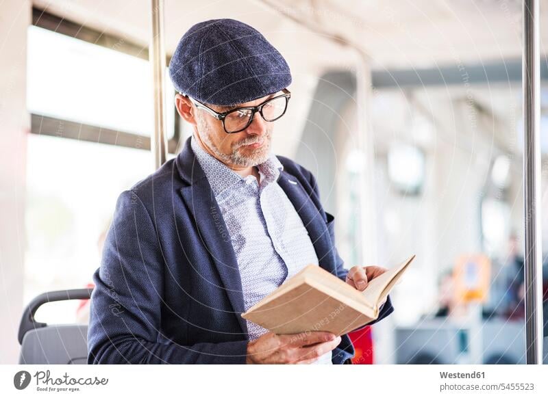 Mann im Bus liest Buch Pendler lesen Lektüre Männer männlich Autobusse Busse Omnibus Omnibusse Bücher Erwachsener erwachsen Mensch Menschen Leute People
