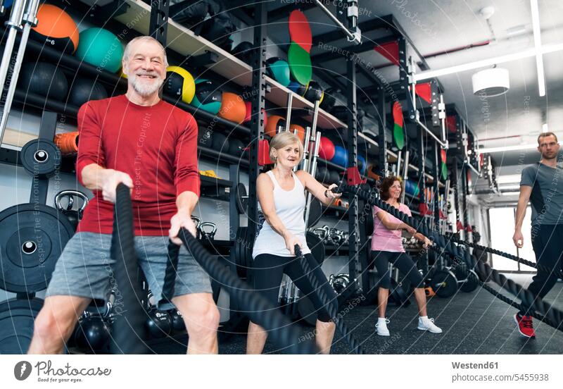 Senioren im Fitnessstudio beim Training mit Kampfseilen Workout ziehen alte ältere trainieren Sport Fitnessclubs Fitnessstudios Turnhalle Battle Rope